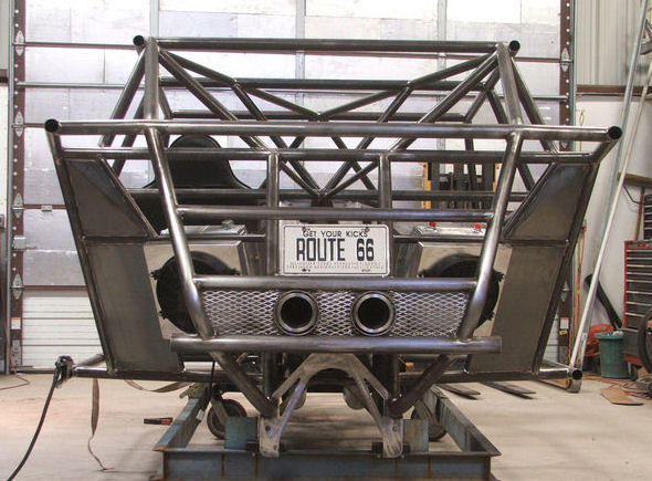 Unpainted tube-steel front bumper guard with mesh insert and Route 66 plate on a shop table