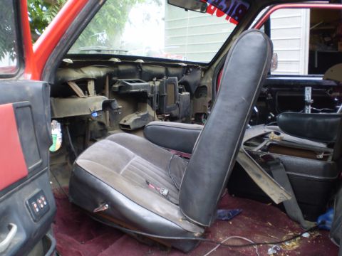 1969 Ford F-250 - The interior of a red truck shows a disassembled dashboard and worn seats, suggesting a restoration project.