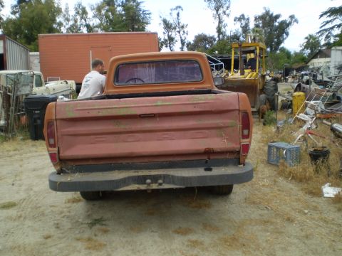 1969 Ford F-250 - This 1973 Ford F-250 pickup truck is seen from the rear in a junkyard setting.