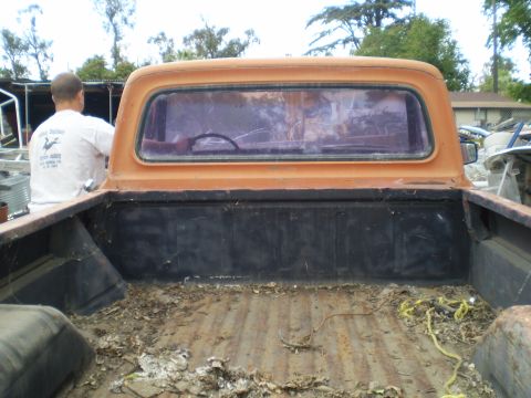 1969 Ford F-250 - Rear view of an orange 1969 Ford F-250 pickup truck, highlighting its bed and cab.