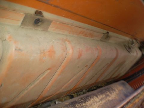 1969 Ford F-250 - The underside of a vehicle's fuel tank shows some wear and orange paint markings.