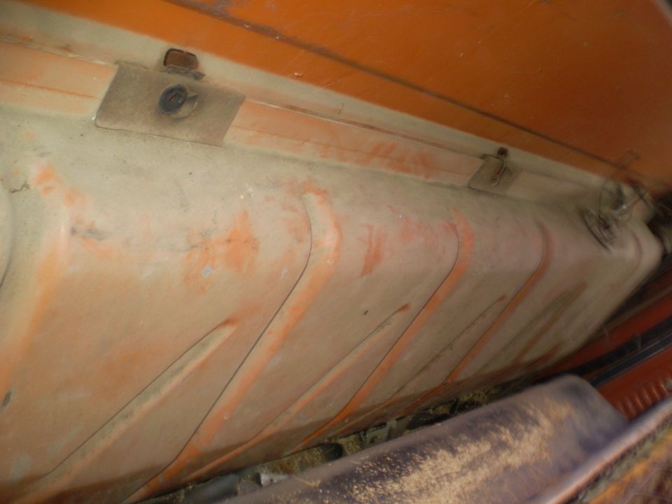 Underside of a vehicle fuel tank with orange paint streaks