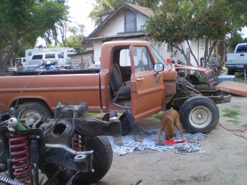 1969 Ford F-250 - This orange 1967 Ford F-100 pickup truck is partially disassembled, with its front end removed for repairs.