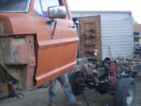 1969 Ford F-250 - Orange truck cab and chassis undergoing work, with suspension components exposed.