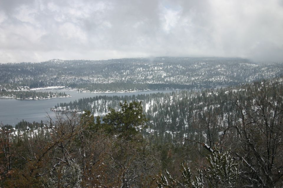 Snowy landscape with a lake and trees, Supermotors.net logo visible