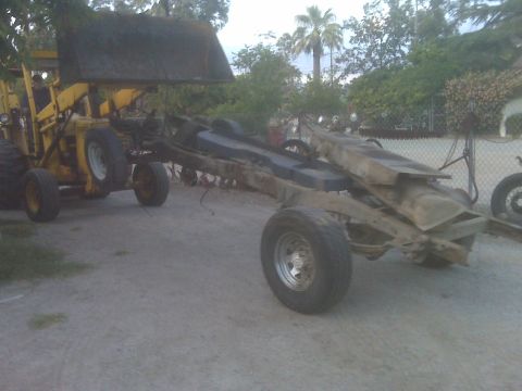 1969 Ford F-250 - A truck chassis is being moved by a loader, with a fuel tank visible.