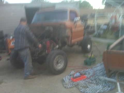 1969 Ford F-250 - An orange pickup truck is being worked on, with its front end disassembled.