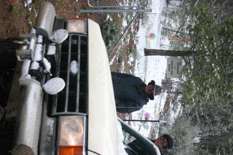 1991 Ford Bronco - A white 1991 Ford Bronco is seen with snow on its front end, parked near a sign indicating 'End of the Road'.
