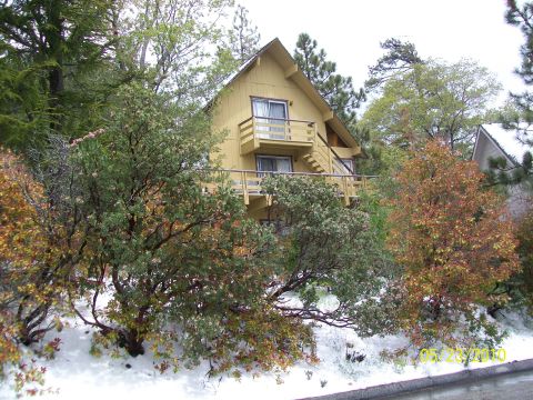1972 Ford Ranchero - A yellow house sits on a hillside with snow on the ground and trees in the foreground.