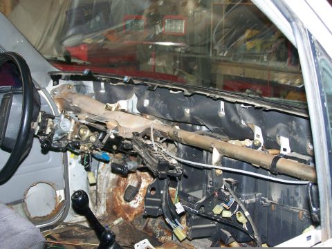 1988 Suzuki Samurai - The interior of a vehicle shows extensive dashboard disassembly, revealing exposed wiring and rusted metal components.