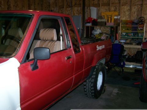 1988 Suzuki Samurai - This red pickup truck has a white front fender and "Snap-on" branding on the side of the bed.