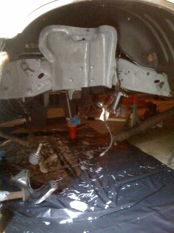 Close-up of vehicle frame and suspension parts, possibly during repair or restoration