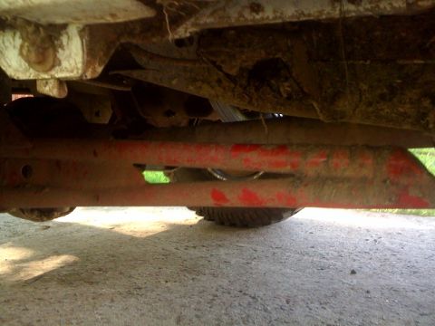 1995 Ford Bronco - The underside of a vehicle shows its frame and suspension components, with a tire peeking out from below.