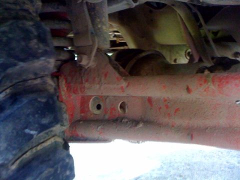 1995 Ford Bronco - Close-up view of the underside of a vehicle, showing suspension and a tire.