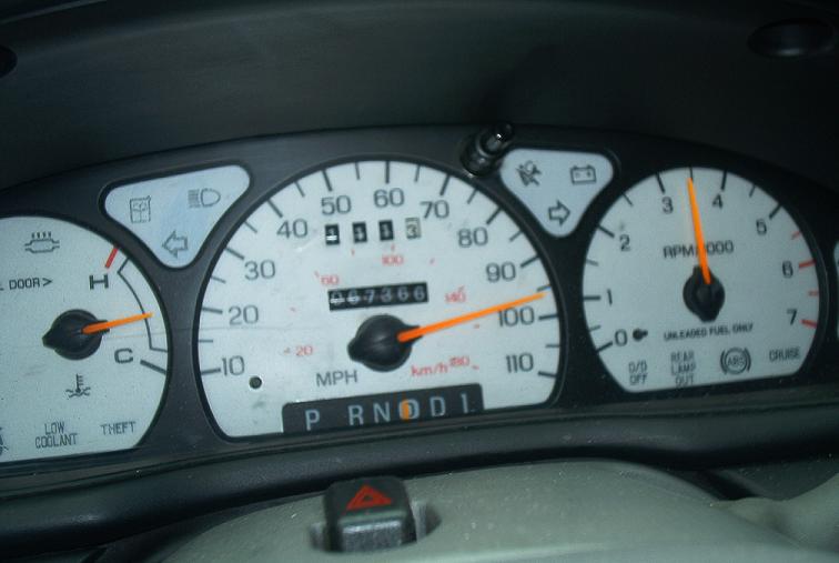 Car dashboard with speedometer, tachometer, and odometer showing 67366 miles