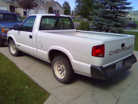2006 Ford E350 - A white Chevrolet pickup truck is parked on a driveway next to a blue SUV.