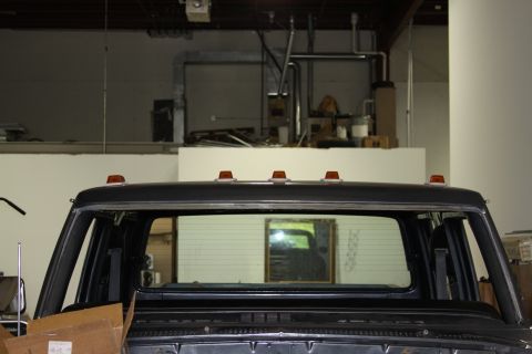 1979 Ford F-250 - The rear of a dark-colored truck cab is visible, showing clearance lights on the roof.