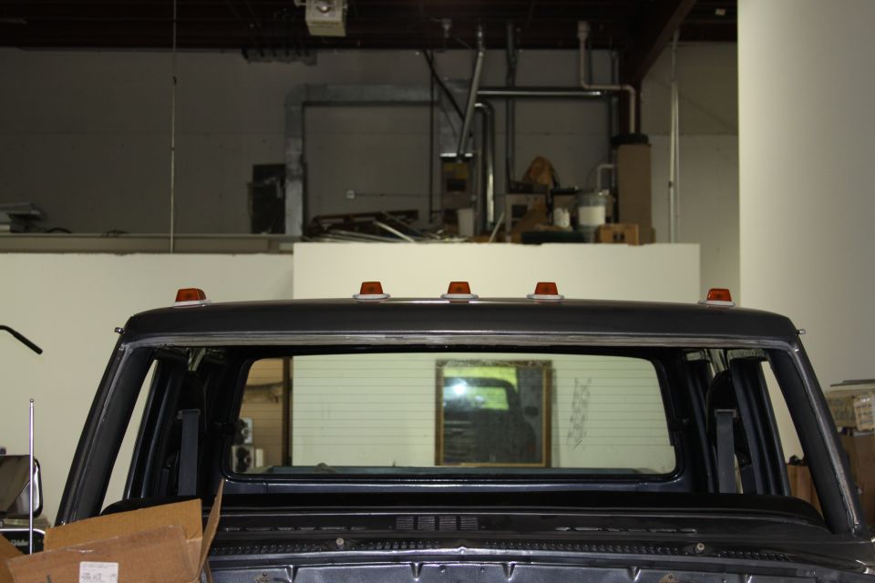 Dark truck cab roof with amber clearance lights and a large rear window