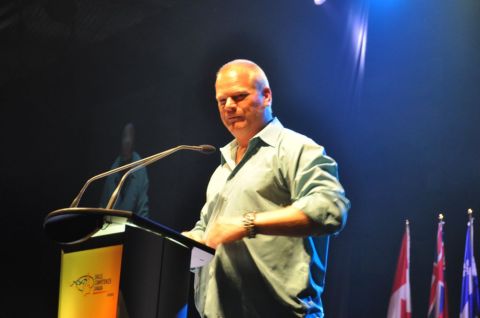 1996 Ford Bronco - A man speaks at a podium during a conference, with flags of Canada and Quebec visible.