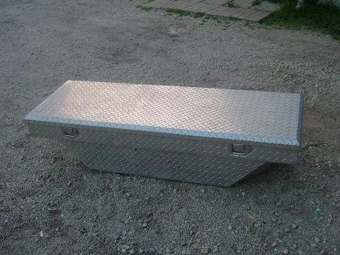 1991 Toyota Tacoma - A diamond plate aluminum toolbox sits on a gravel surface, likely for storage in a truck bed.