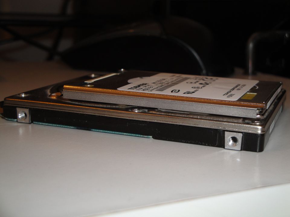 Two stacked computer hard drives on a white surface