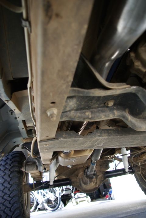 1995 Ford Bronco - The underside of a vehicle reveals its mechanical components, including the exhaust system and suspension.