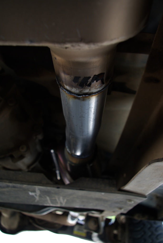 Close-up of an exhaust pipe showing a weld joint and some black markings