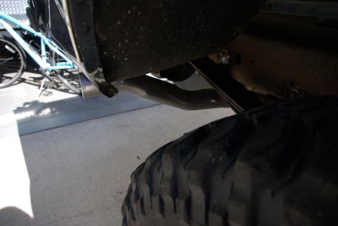 1995 Ford Bronco - Close-up view of a vehicle's exhaust pipe and tire, with a bicycle visible behind it.