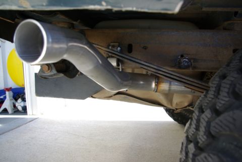 1995 Ford Bronco - Close-up view of a vehicle's exhaust pipe system, showing the muffler and piping.
