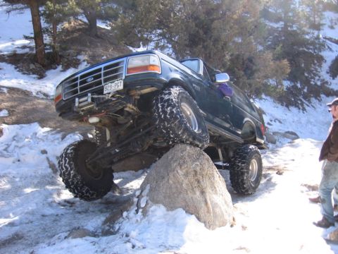 1994 Ford Bronco - A modified Ford Bronco navigates a rocky, snow-covered trail.