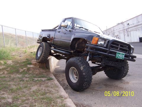 1994 Ford Bronco - This modified Toyota pickup truck is shown with its front tires on a curb and its rear tires on the ground.