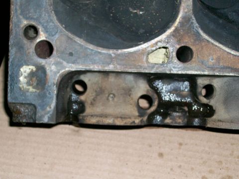 1973 Ford Ranchero - A close-up view of an engine cylinder head shows oil residue and several bolt holes, with a small numeral '6' embossed on the surface.