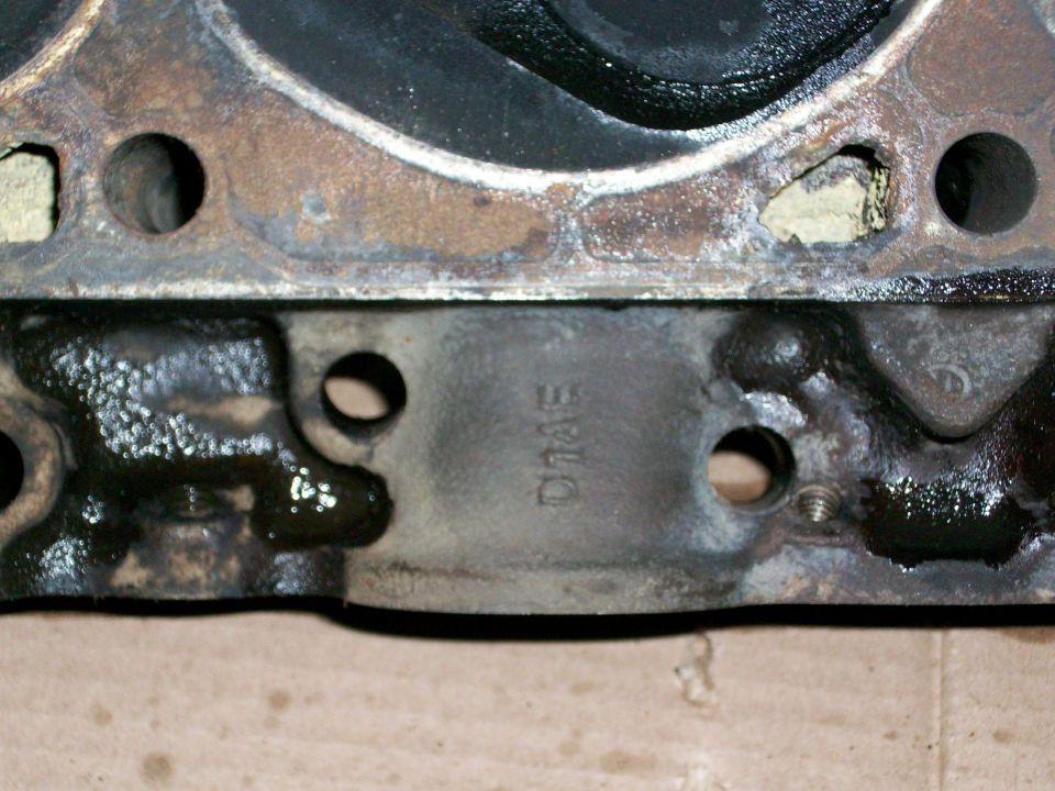 Engine cylinder head with cast-in text 'D14E' and oil residue