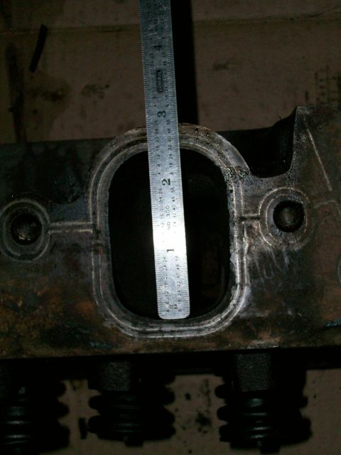 1973 Ford Ranchero - Measuring an engine part with a ruler. The part is dark and appears to be metal.