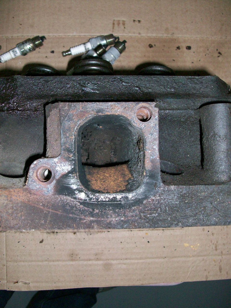 Engine cylinder head with spark plugs and carbon buildup