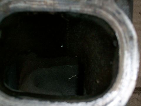 1973 Ford Ranchero - A view inside an engine intake port, showing its internal texture and dark color.