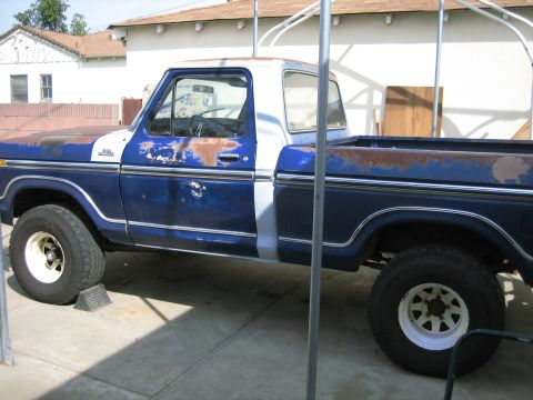 1979 Ford F-150 - This 1979 Ford F-150 pickup truck shows significant rust and wear on its blue and white paint scheme.