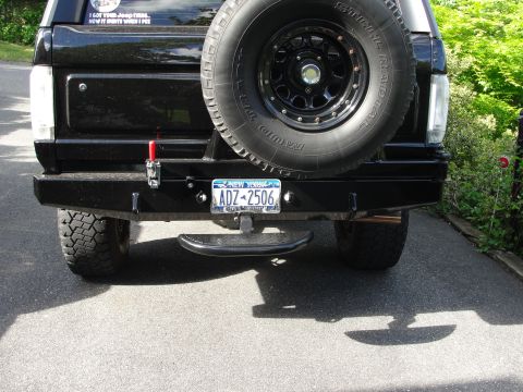1995 Ford Bronco - The rear of a black SUV shows a spare tire mounted externally, a tow hitch, and a New York license plate.