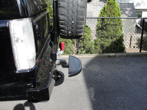 1995 Ford Bronco - Rear view of a black 1995 Ford Bronco, showing the bumper, spare tire mount, and a step.