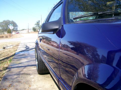 1991 Ford Mustang - Side view of a blue car, focusing on the door and wheel well area.