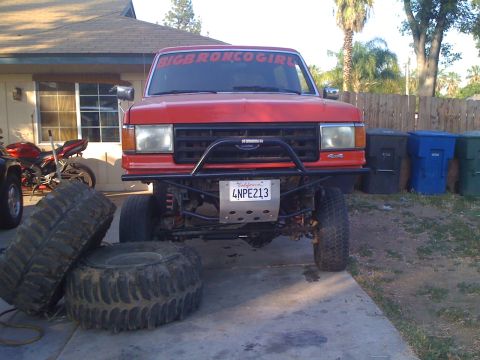 1969 Ford F-250 - This red pickup truck features a custom bumper, off-road tires, and a "BIGBRONCO GIRL" banner on the windshield.