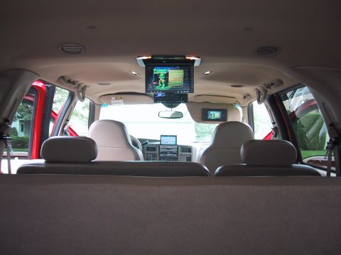 2001 Ford Excursion - The interior of a large SUV is shown, multiple screens and entertainment systems.