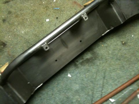 1995 Ford Bronco - A custom metal bumper with a tubular bar and mounting points is shown on a workshop floor.