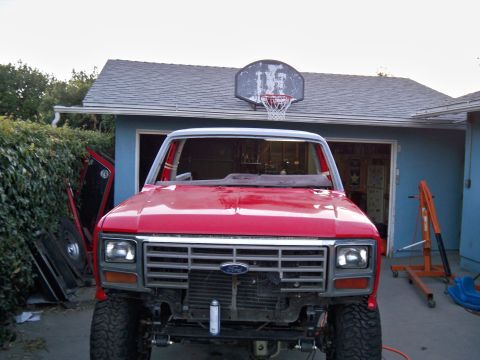 1985 Ford Bronco - 1985 Ford Bronco front end visible, undergoing repairs in a residential garage setting.