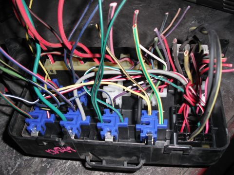 1991 Ford Bronco - A complex fuse box with a tangle of red, blue, green, yellow, and other colored wires.