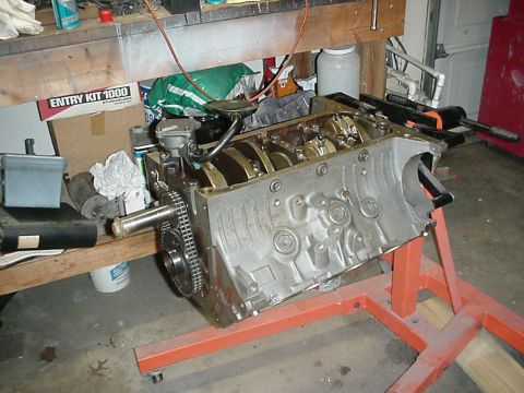 1968 Mercury Cougar - Engine block assembly on a stand in a workshop setting, with various tools and parts nearby.
