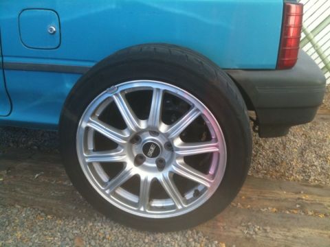 2005 Subaru Impreza - A silver BBS wheel is mounted on a blue car, with the rear quarter panel and taillight visible.