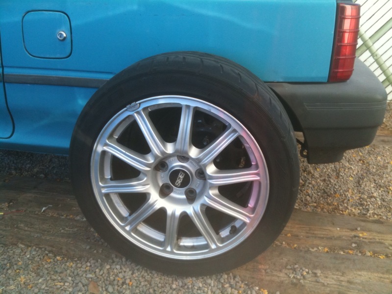 Silver BBS wheel on blue car's rear quarter panel
