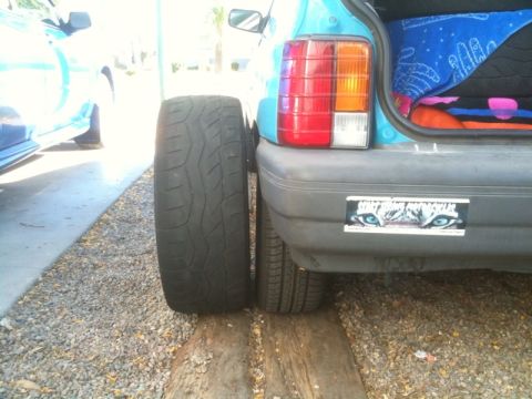 2005 Subaru Impreza - Wide tire mounted on the rear of a car, next to the standard tire.