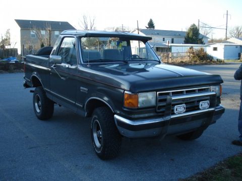 1988 Ford Bronco - This Ford Bronco is seen from a three-quarter front angle, parked outdoors on a paved surface.